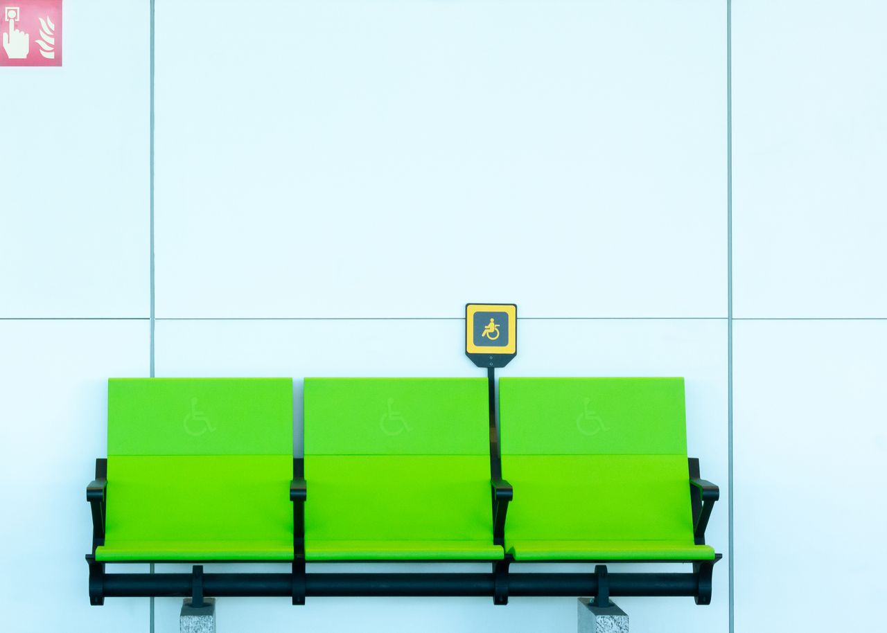 Vibrant green seats with handicap signs against a minimalist background.